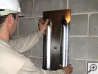 Mounting a foundation wall plate for an earth anchor installation in Bemidji.