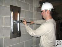 Attempting to straighten a bowed foundation wall by straightening a wall anchor system in a Menomonie home.