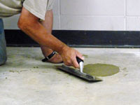 Repairing the cored holes in the concrete slab floor with fresh concrete and cleaning up the Eau Claire home.