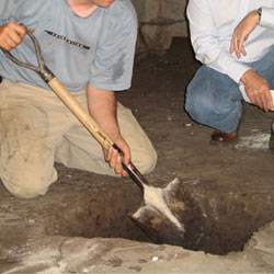 Digging a hole for the engineered fill used in a crawl space support system installation in Eau Claire