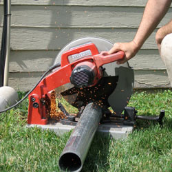 Cutting the support beam for a crawl space jack post outside a Duluth home.