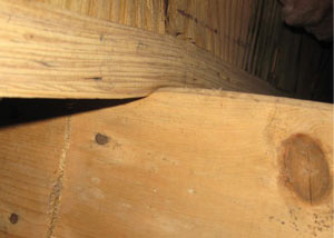 A failing girder showing signs of compression damage in a Duluth home