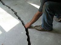 a severely damaged cracked concrete slab floor in Eden Prairie