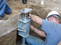Foundation repair contractors installing the foundation bracket in Hibbing.