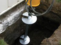 Installing a helical pier system in the earth around a foundation in Duluth