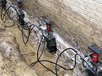 Using foundation push piers to lift a foundation during a repair in Duluth.