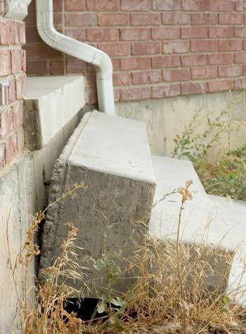 sinking outdoor concrete steps showing cracking and soil washout in Hibbing