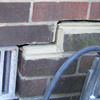A closeup of a failed tuckpointing job where the brick cracked on a Bemidji home.