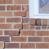 long jagged cracks starting at the corner of a window along a brick wall on a Hibbing home