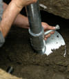 Eau Claire helical pier installation nearing completion, with the blade being advanced into the foundation soils.