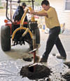 Digging a hole in the garage floor to make room for a wall anchor installation in Bemidji, Minnesota and Wisconsin
