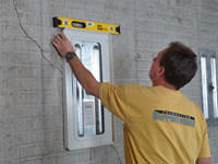 Positioning a wall plate cover on a foundation wall in Eau Claire.