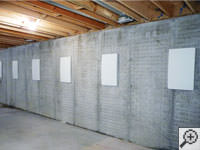 Wall anchor covers installed along a foundation wall that has been straightened in Duluth.