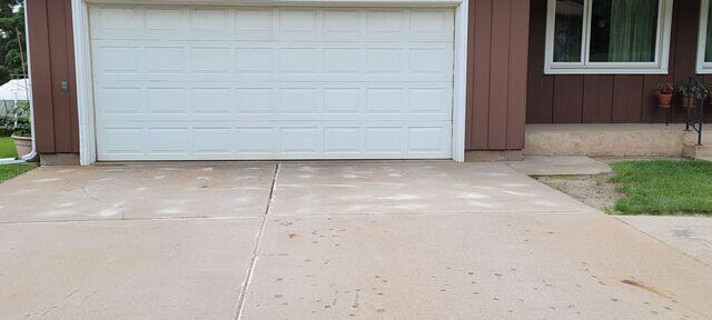 Uneven concrete driveway slabs leading to a garage entrance in Virginia, MN during a professional repair inspection.