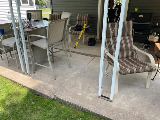 Outdoor backyard concrete patio in Thorp, WI set up with tables and chairs after professional repair.