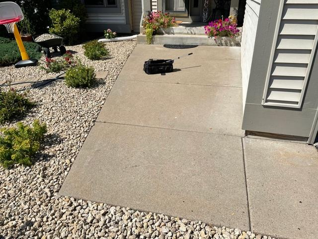 Uneven concrete front walkway slabs leading to the home entrance porch in Andover, MN before repair.