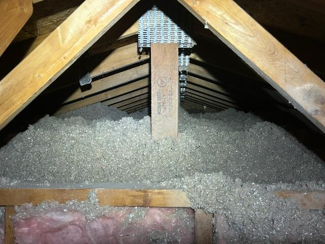 Deep layers of newly installed truSoft blown cellulose insulation filling the attic floor beneath wooden roof trusses in Circle Pines Minnesota