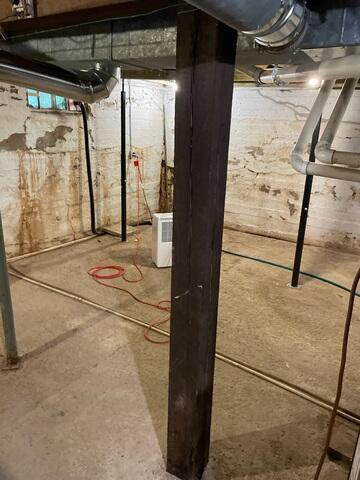 Old wooden central support beam in a basement requiring structural repair in Kettle River, MN.