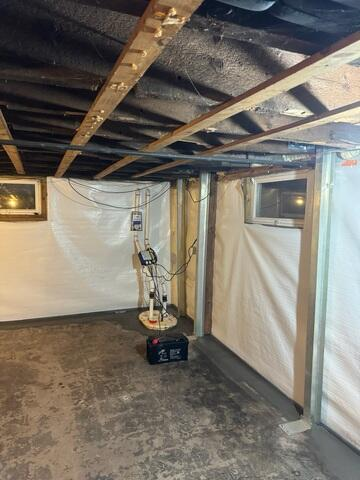 TripleSafe sump pump system and backup battery installed alongside clean white CleanSpace wall vapor barrier in Ashland, WI.