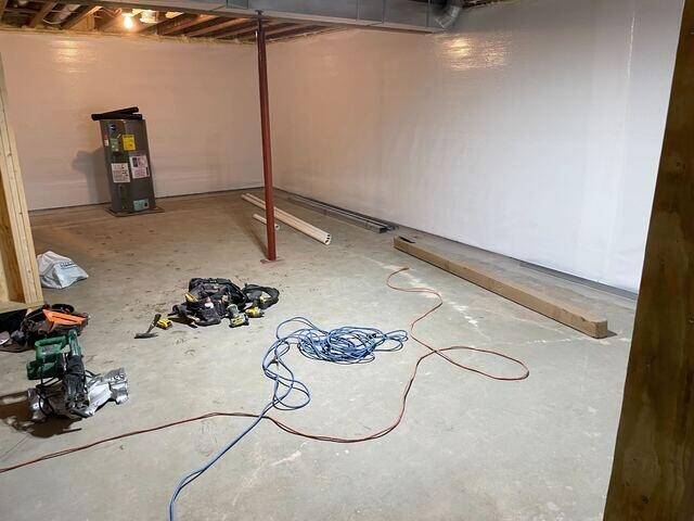 Bright white CleanSpace wall liner sheets installed across a basement perimeter during a waterproofing project in Birchwood, WI.