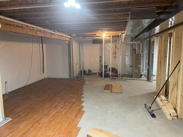 basement-waterproofing-birchwood-wi-flooding-before Severe groundwater pooling on a concrete basement floor with heavy water stains on block foundation walls in Birchwood, WI before repair.