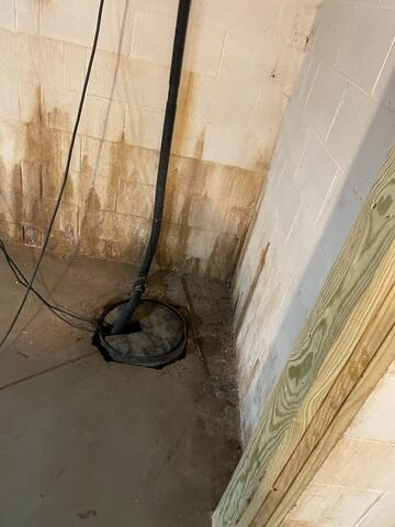 A newly installed heavy-duty sealed sump pump and commercial-grade dehumidifier running along a white encapsulated wall in Birchwood, WI.