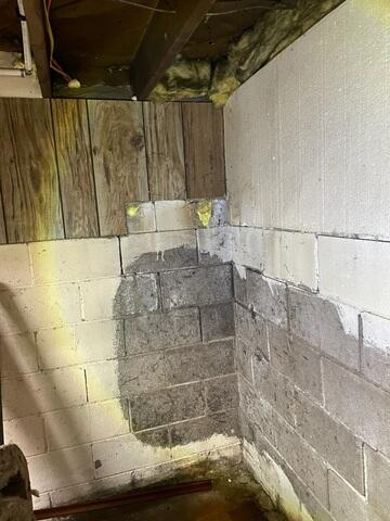 Severe water staining and moisture damage on concrete block foundation walls in a Cloquet, MN basement before repair.