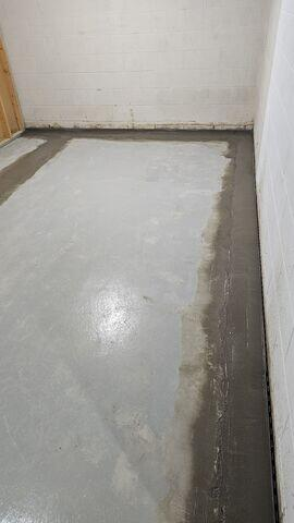 Completed sub-floor interior perimeter drainage track running along concrete block foundation walls in a Cohasset, MN home.