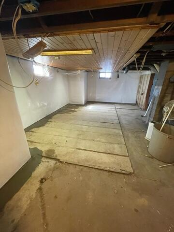 A fully waterproofed and clean basement featuring white CleanSpace wall liners and freshly concreted floor perimeters in Conrath, WI.