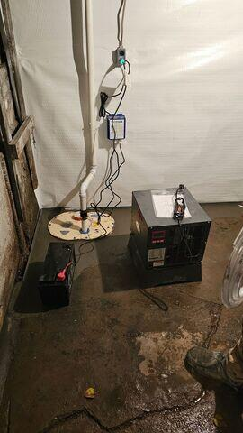 A DoubleSafe sump pump system and SaniDry Sedona dehumidifier unit operating next to white CleanSpace wall liners in Superior, WI.