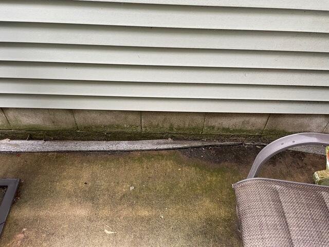 Sinking concrete patio pooling water against the foundation block wall in Blaine, MN.