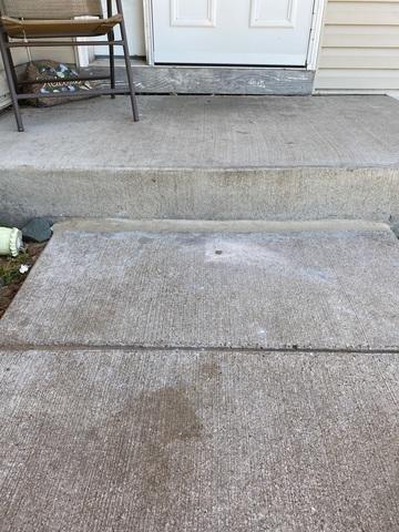 Perfectly leveled concrete sidewalk slab flush with the entry step after PolyLevel foam repair in Hammond, WI.