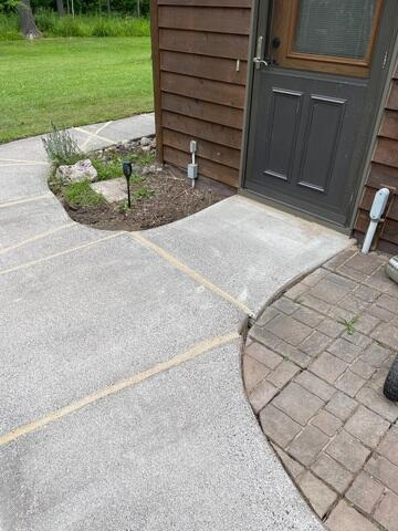 Leveled and stabilized concrete sidewalk curved pathway near entry door sealed with NexusPro in South Range WI
