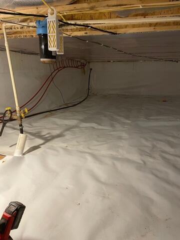 Damp unconditioned crawl space with a raw sand floor before encapsulation in Spooner Wisconsin