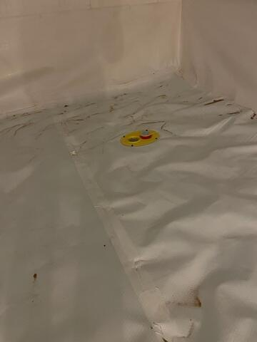 Sealed seams of a bright white CleanSpace vapor barrier system inside a dry crawl space in Spooner Wisconsin