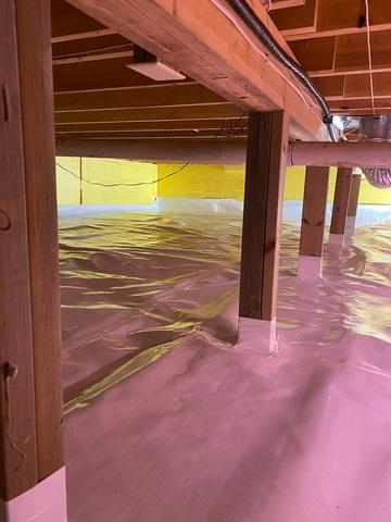 Clean high performance vapor barrier lining the floor and sealing the wooden framing support columns inside a crawl space near Aitkin Minnesota