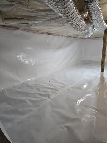 Bright white CleanSpace vapor barrier neatly sealing the walls and floor of a crawl space in Balsam Lake Wisconsin