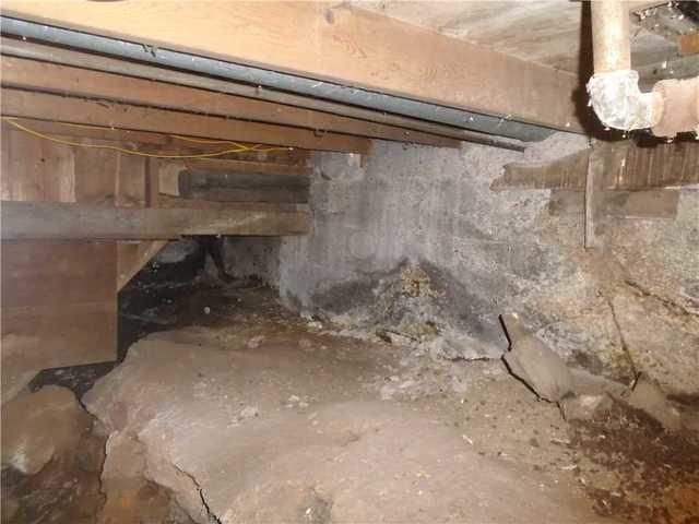 Damp and unsupported concrete block crawl space area before structural repair and insulation in Cloquet Minnesota