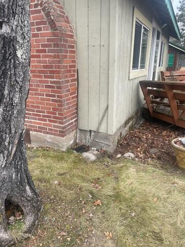Exterior view of a rustic cabin undergoing crawlspace foundation stabilization and piering in McGregor Minnesota