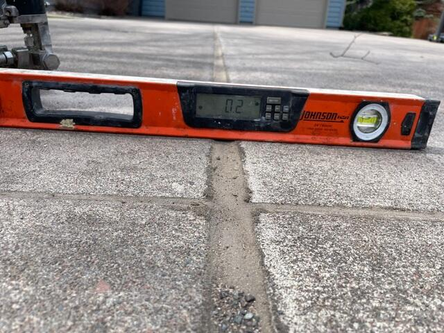 Digital level instrument confirming flat concrete alignment after PolyLevel injection in Superior WI