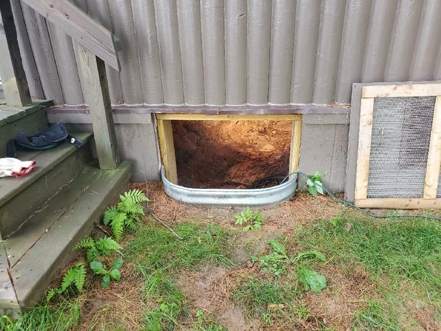 Unsealed crawl space entry with dirt floor before encapsulation and repair in a Barnum Minnesota home