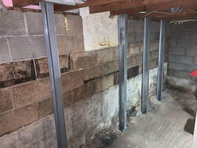 PowerBrace steel I beams installed to support and stabilize a cracked bowing concrete block foundation wall in Cloquet Minnesota