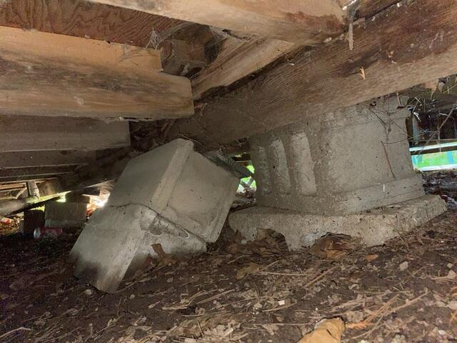 Unstable decaying wood posts under a shifting cabin foundation in Garrison MN before repair