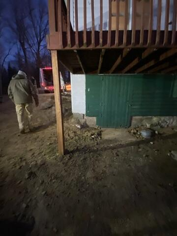 Exterior view of a lakeside cabin structure on a steep slope undergoing foundation stabilization in Hackensack Minnesota