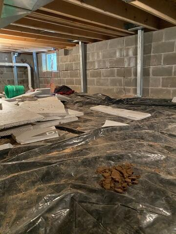 Heavy duty PowerBrace steel I-beams installed vertically against a basement foundation wall in Hayward Wisconsin