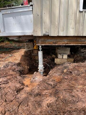 Heavy-duty SmartJack steel post installed under a settling cabin in La Pointe WI