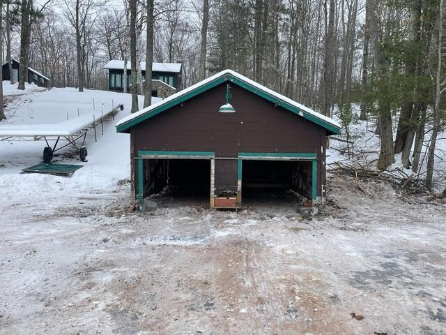 Exterior view of a historic family boathouse stabilized in winter in Lake Nebagamon WI