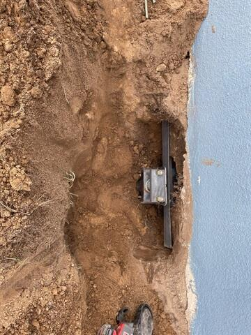 Excavated foundation wall with a heavy-duty steel pier bracket installed in Mondovi WI