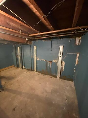 Industrial GeoLock channel anchors installed along a concrete block basement wall to correct bowing in Superior Wisconsin