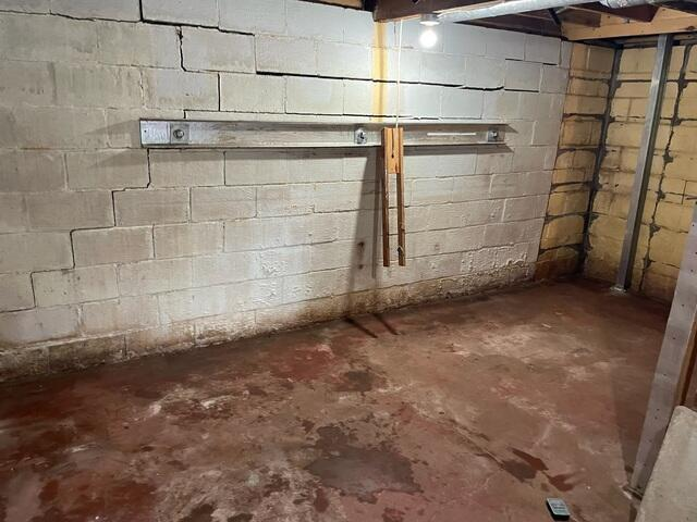 A completed foundation repair project in a Danbury, WI basement featuring a heavy galvanized steel GeoLock waler bar cleanly reinforcing a cracked masonry wall.